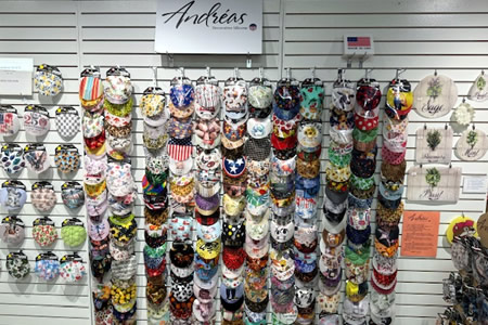 Colorful Andreas oven mitts and pot holders with assorted patterns hanging on a retail wall