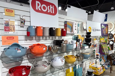 Rosti mixing bowls, cookware, and kitchen accessories arranged on store shelving